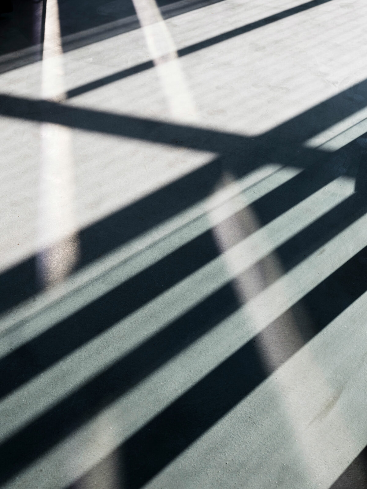 Schatten auf dem Fussboden im Bauhaus Museum zieht geometrische Linien.