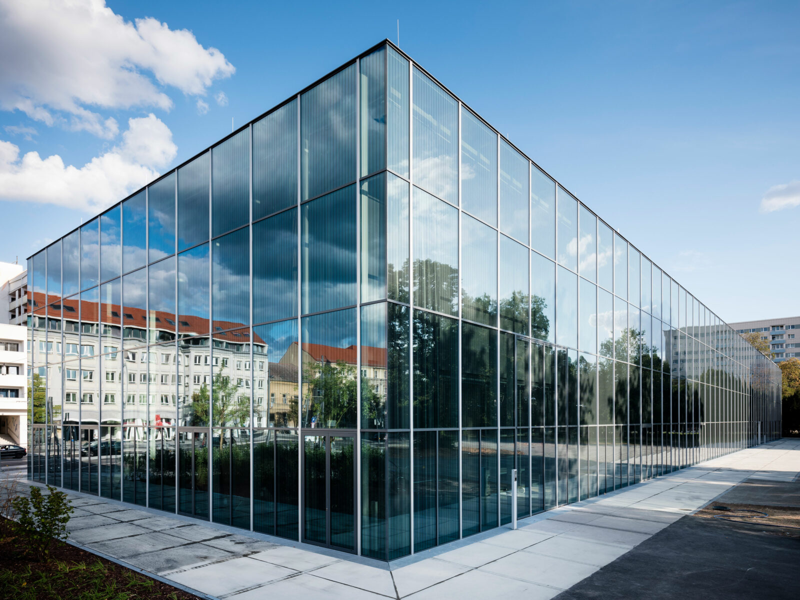 Ecke des Bauhaus Museums Dessau. In der Glasfassade spiegelt sich die Umgebung.